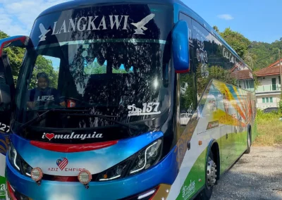 Bas persiaran VIP 44 tempat duduk berwarna biru dilihat dari sudut mengiring hadapan bas
